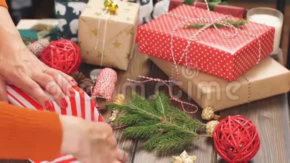 女性手装饰圣诞礼物红色盒子当前包装理念视频的预览图