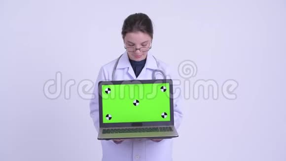 快乐的年轻美丽的女医生在讲手提电脑视频的预览图