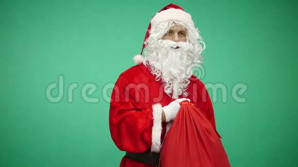 圣诞快乐穿红色西装的圣诞老人在绿色屏幕背景色键的盒子里送出礼物视频的预览图