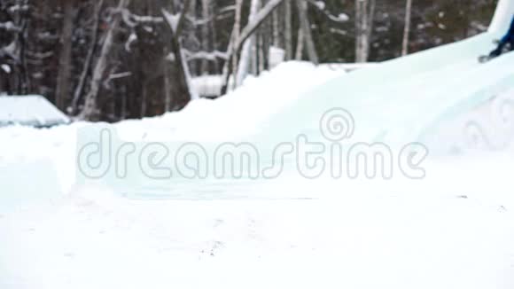 男孩在冬季公园滑下山视频的预览图