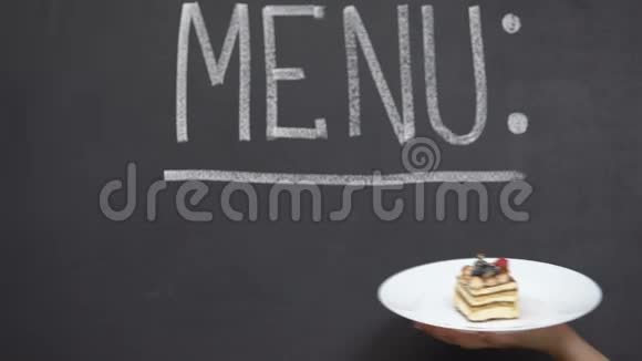 菜单写在黑板上手在盘子上演示开胃蛋糕面包店视频的预览图