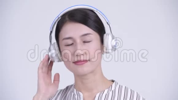 快乐美丽的亚洲女商人闭着眼睛听音乐视频的预览图