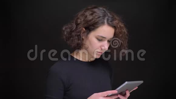 年轻的白种人女性一边看着平板电脑一边看着摄像机一边开心地笑视频的预览图