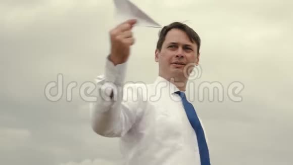 穿西装的商人在乌云密布的背景下用纸飞机发射玩具视频的预览图