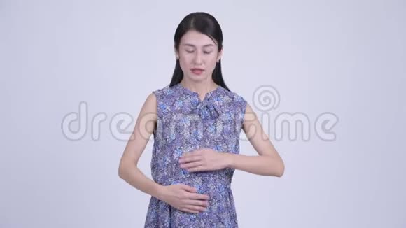 美丽的亚洲孕妇手指在嘴唇上视频的预览图