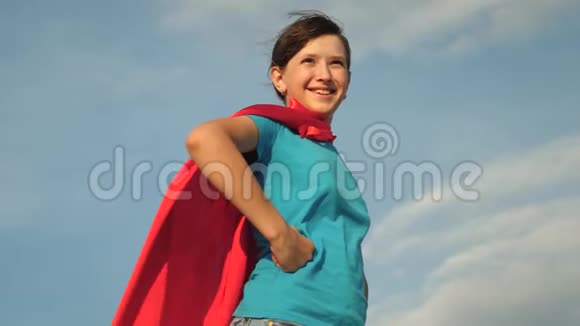 少女超级英雄穿着红色斗篷站在田野上斗篷迎风飘扬慢动作女孩的梦想视频的预览图