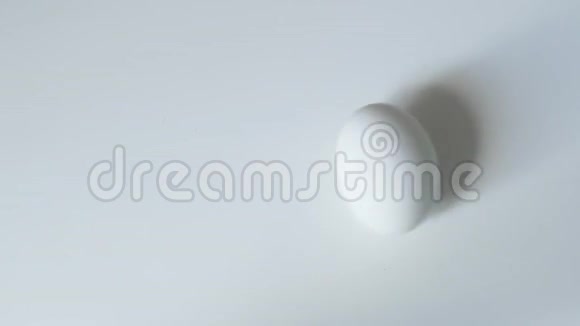 鸡蛋旋转鸡蛋旋转白色背景顶部视图蛋在白色背景上旋转和滚动快乐视频的预览图