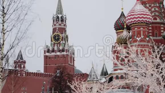 俄罗斯莫斯科2018年12月白天在雪中倾斜圣巴西尔大教堂和斯帕斯卡塔的慢动作视频的预览图