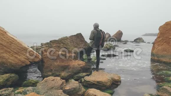 年轻摄影师用数码单反相机拍摄海洋悬崖视频的预览图