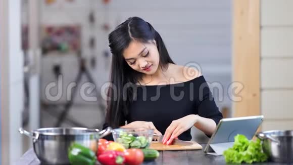 现代漂亮的亚洲女性家庭主妇用刀子烹饪新鲜沙拉切菜视频的预览图