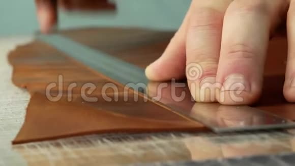 工匠用办公刀把半张真皮切成一张手工制造的关门视频的预览图