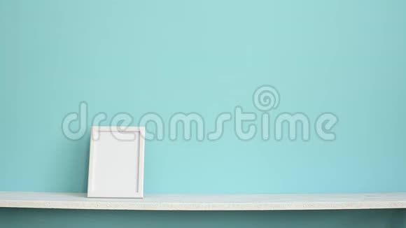 现代客房装饰与相框模型白色架子用手放盆栽仙人掌贴在青绿色墙上视频的预览图