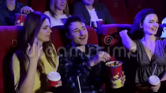 青少年坐在电影院看喜剧吃爆米花喝可乐视频的预览图