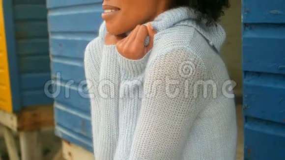 年轻的非洲裔美国妇女站在海滩小屋里瑟瑟发抖视频的预览图
