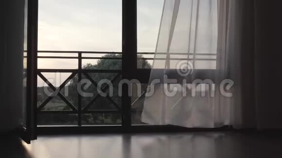 巨大的木制打开的窗户窗帘随风飘扬阳台后面美丽的夏日景观照相机视频的预览图