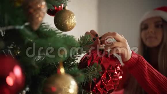 圣诞老人帽女孩装饰圣诞树视频的预览图