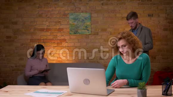 成年成功女商人使用笔记本电脑兴奋并与两名女性庆祝的特写镜头视频的预览图