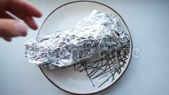 沙玛烤肉串用箔纸拆包放在盘子里视频的预览图