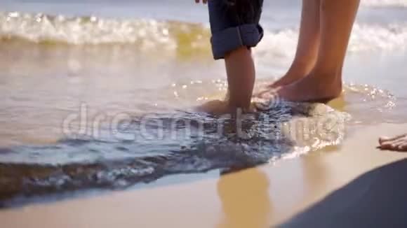 特写男女孩子脚在沙滩上孩子们脚踩在河岸上视频的预览图