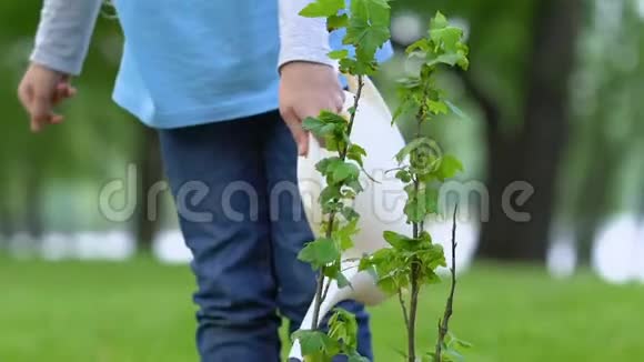 女学生用罐头浇灌树苗自然保育生态理念视频的预览图