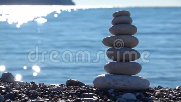 海滩上的禅石完美的冥想宁静的禅坐背景与沙滩的岩石金字塔象征视频的预览图