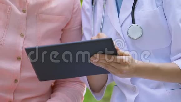 女性治疗师显示平板电脑公园的高级女性检查结果视频的预览图