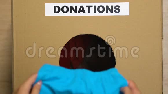 手把旧衣服放在盒子里上面有捐赠标志为穷人做慈善视频的预览图