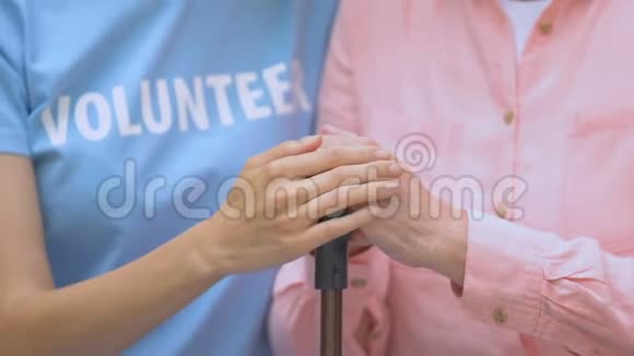女志愿者用手杖抚摸老年妇女的手保健视频的预览图