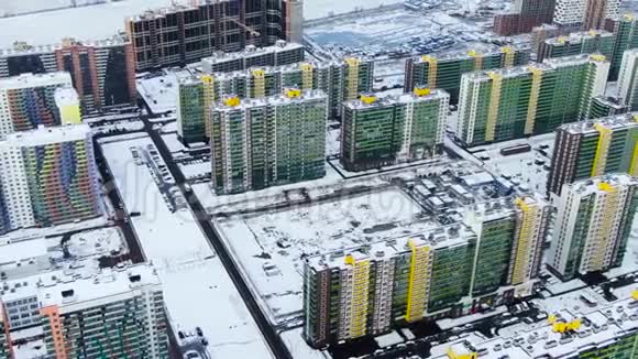 鸟瞰现代城市的高楼大厦停放和移动汽车沿街道覆盖的雪动作城市视频的预览图