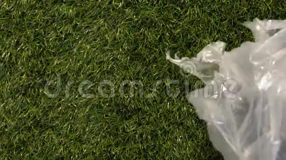风吹纸袋扔在绿草上环境污染的概念视频的预览图