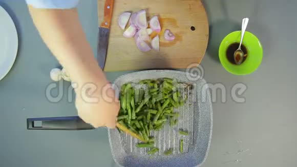 雌性手把豆子混合在锅里切蘑菇和洋葱时光飞逝视频的预览图