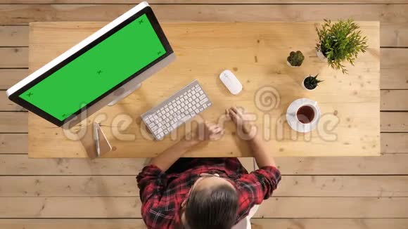 偶然的女人在电脑前的现代办公室里喝咖啡绿色屏幕模拟显示视频的预览图