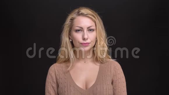 一幅美丽的白种人长发女子的肖像在黑色背景下将她的头负扭成相机视频的预览图