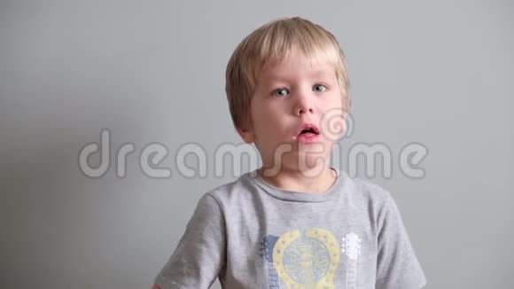 可爱的小男孩在灰色背景下咳嗽视频的预览图