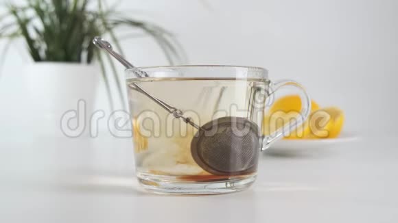 在玻璃杯里泡茶在白色的厨房桌子上用茶过滤器快关门视频的预览图