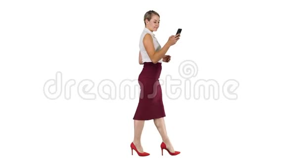 漂亮的年轻女人正在她的智能手机设备中使用一个应用程序发送短信并在白色背景下行走视频的预览图
