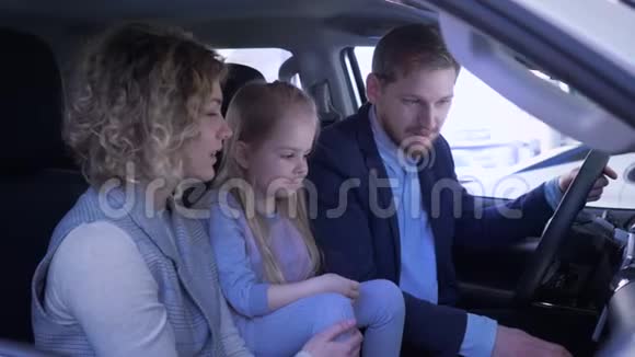 汽车生意快乐的微笑爸爸妈妈和小女孩回顾家庭汽车挥舞钥匙和拇指同时视频的预览图