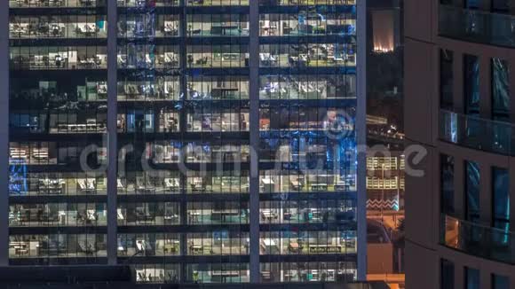 办公大楼在深夜外部内部灯亮着人们在夜间工作视频的预览图