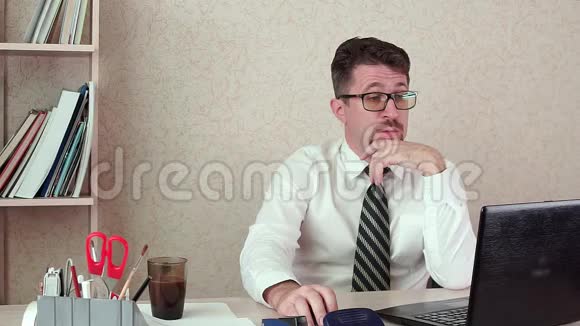男办公室经理留着胡子和眼镜对笔记本电脑很满意视频的预览图