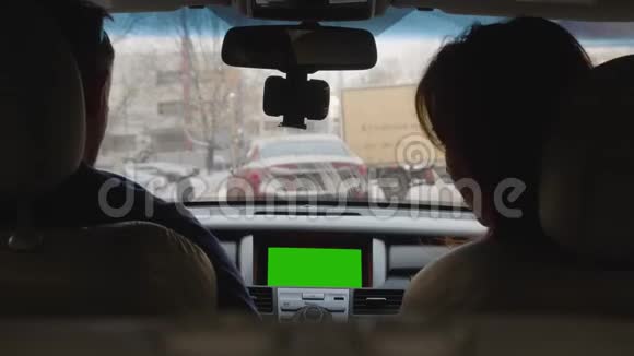 人把智能手机放在挡风玻璃上的支架上一对夫妇准备在城里开车背面视频的预览图