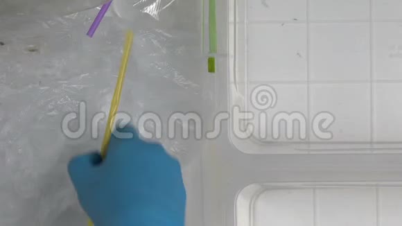 手套上的手在不同的容器中分拣塑料废料视频的预览图