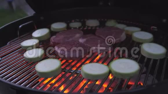 牛排被烤在靠近蔬菜的火上相机从左到右移动视频的预览图