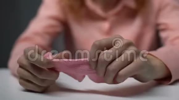 沮丧的年轻女士揉着粉红色的儿童袜子绝望地哭泣不孕视频的预览图