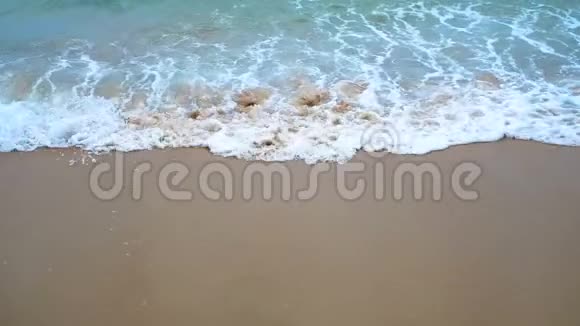 在一个多云的夏天波浪翻滚到沙质海岸上视频的预览图