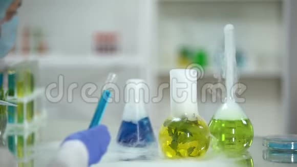 生物化学家用蓝剂将有机液从瓶中滴出视频的预览图