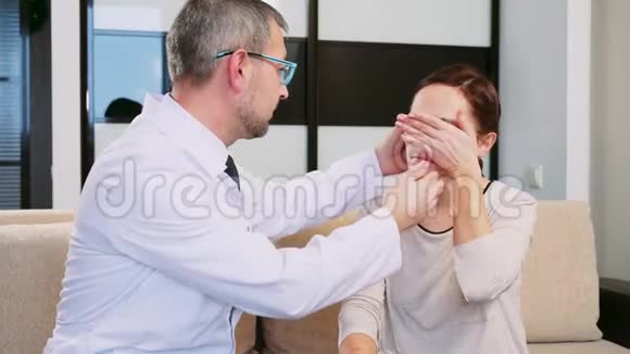 男医生把助听器放在女人耳朵里一个哭着试助听器的女人她很难过视频的预览图