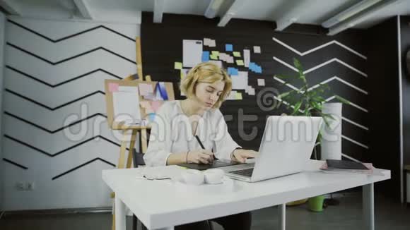 年轻的平面设计师短发使用平板电脑工作视频的预览图