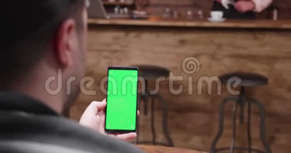男人在手机上用绿色屏幕显示视频的预览图