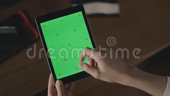 女性手在绿色屏幕平板上做手势女人用手指滑动平板电脑视频的预览图