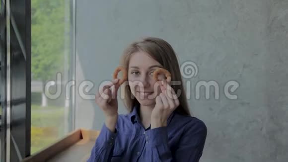 女孩带着洋葱圈到她的脸上在一家快餐店微笑视频的预览图